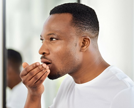A black man with his hand covering his mouth